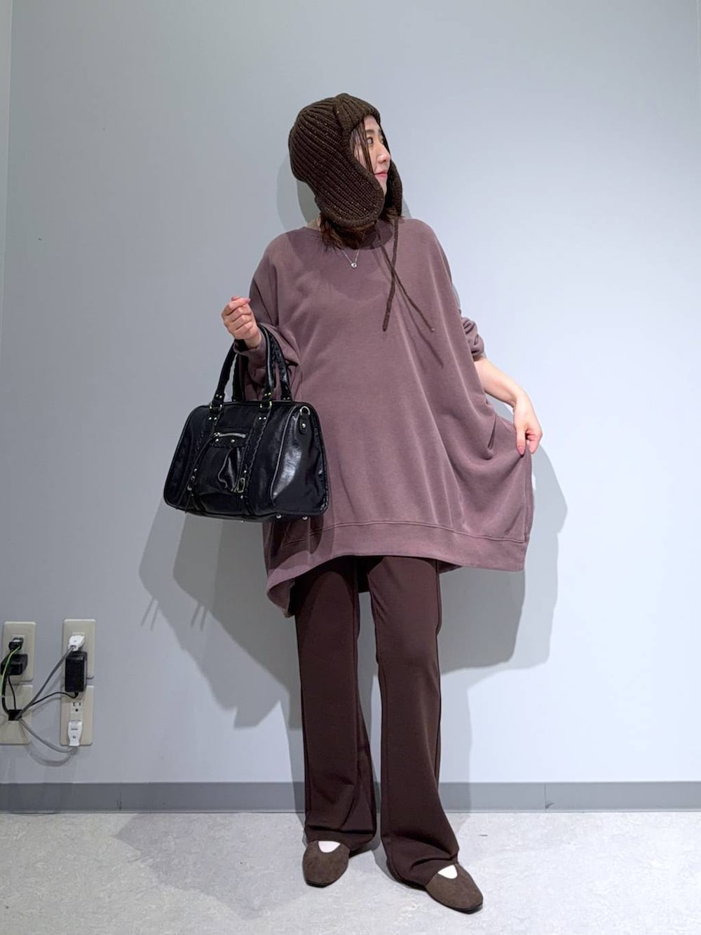 ブラウン系のパンプス、ブラック系のボストンバッグ、ブラウン系のスウェットを着用したレディースの秋コーディネートの3枚目の写真