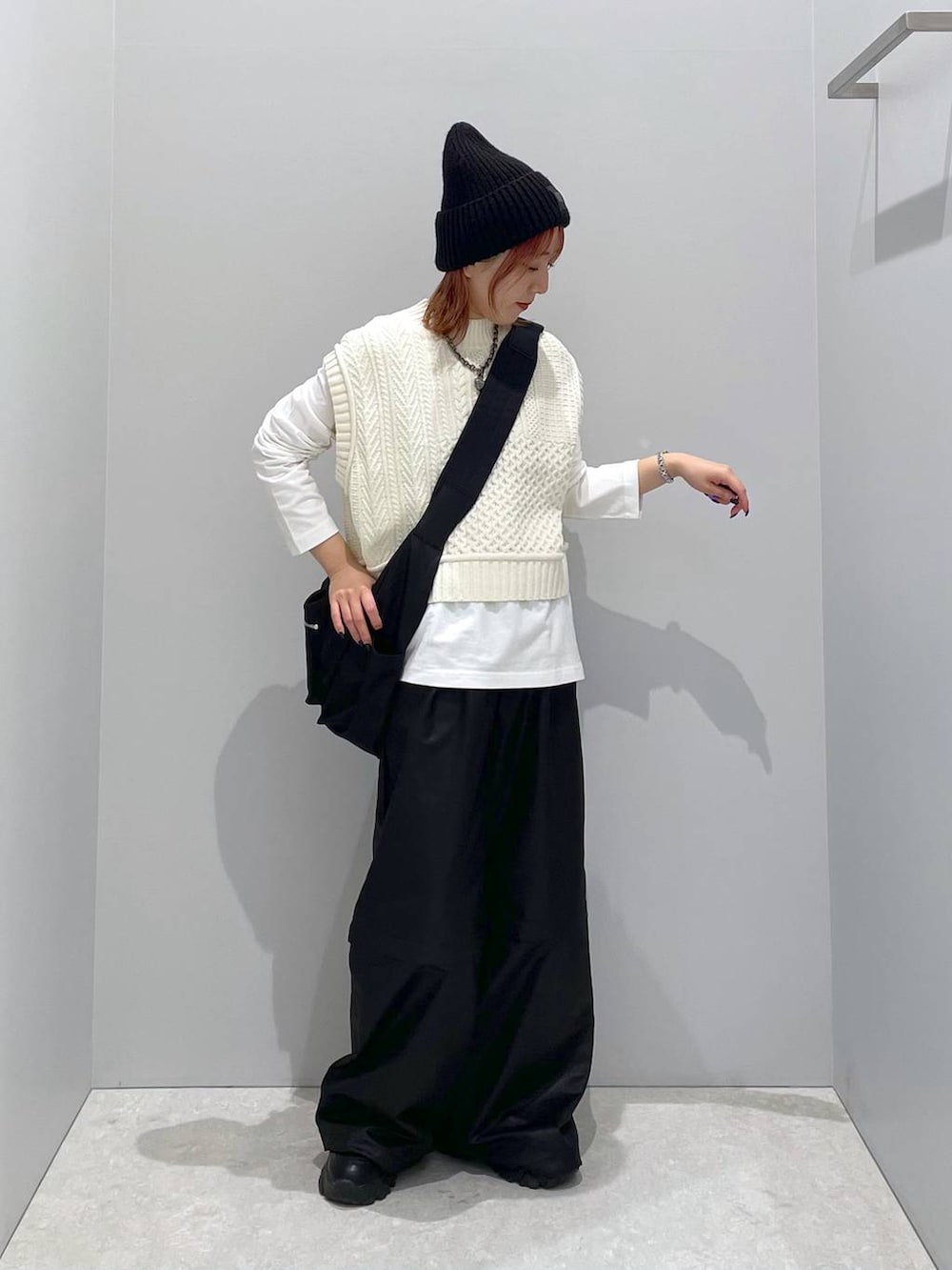ホワイト系のベスト、ブラック系のショルダーバッグ、ホワイト系のTシャツ/カットソーを着用したレディースの秋コーディネートの3枚目の写真