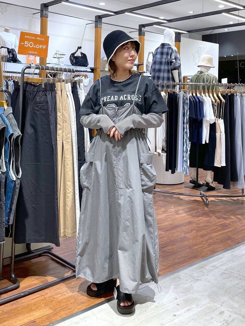 ホワイト系のTシャツ/カットソー、ブラック系のサンダル、グレー系のワンピースを着用したレディースの春コーディネートの2枚目の写真