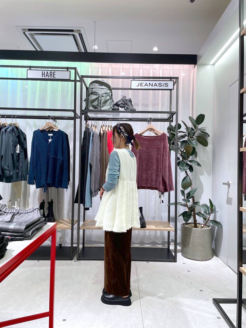 ホワイト系のベスト、ブラウン系のスカート、ブラック系のサンダルを着用したレディースの秋コーディネートの3枚目の写真