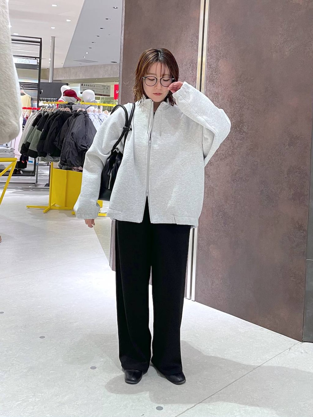 グレー系のブルゾン、ブラック系のサロペット/オーバーオール、ブラック系のボストンバッグを着用したレディースの冬コーディネートの3枚目の写真