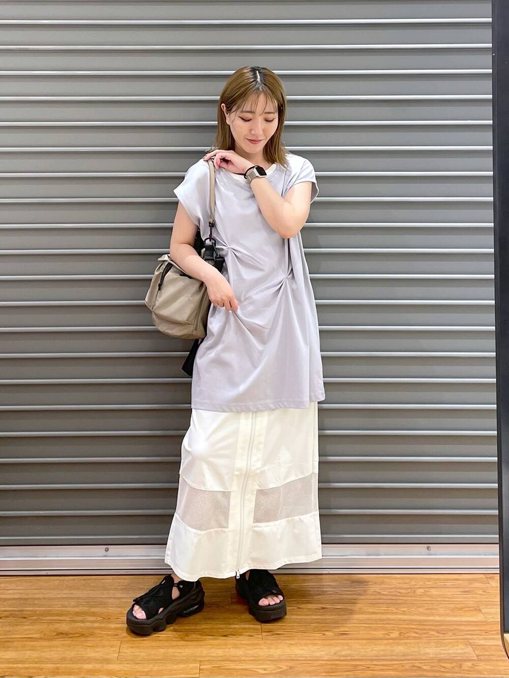 ベージュ系のショルダーバッグ、ホワイト系のスカート、グレー系のTシャツ/カットソーを着用したレディースの夏コーディネートの2枚目の写真