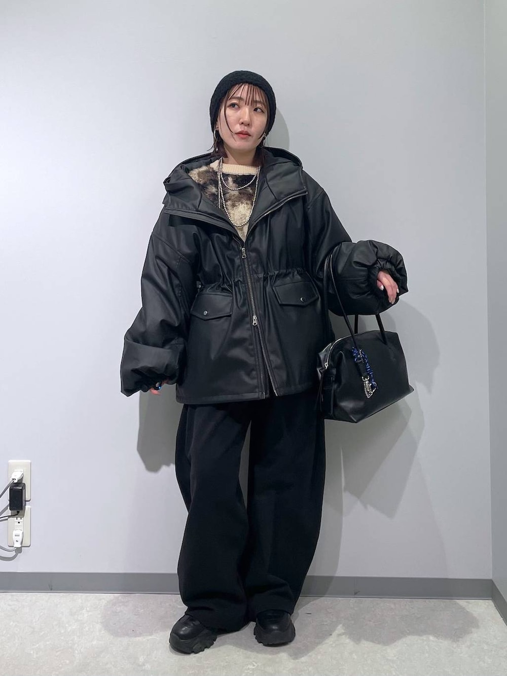 ブラウン系のニット/セーター、ブラック系のボストンバッグ、ブラック系のスウェットパンツを着用したレディースの冬コーディネートの4枚目の写真