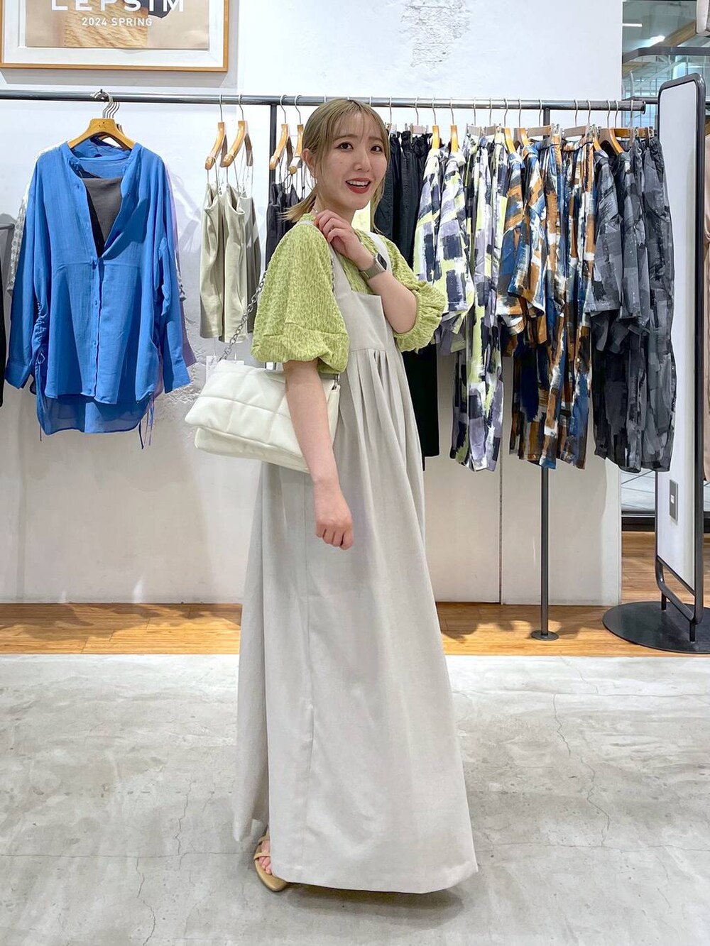 ブラック系のショルダーバッグ、ベージュ系のサンダル、グリーン系のTシャツ/カットソーを着用したレディースの春コーディネートの2枚目の写真