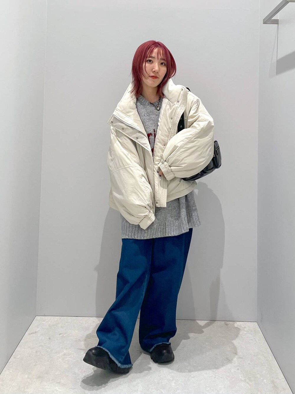 ホワイト系のその他アウター、ブラック系のショルダーバッグ、グレー系のニット/セーターを着用したレディースの秋コーディネートの3枚目の写真