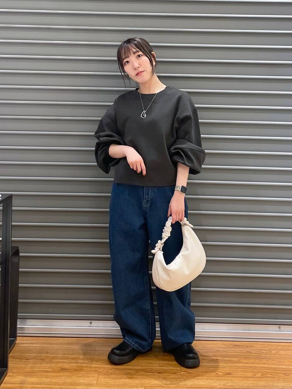 ホワイト系のショルダーバッグ、グレー系のTシャツ/カットソー、ブルー系のデニムパンツを着用したレディースの春コーディネートの2枚目の写真