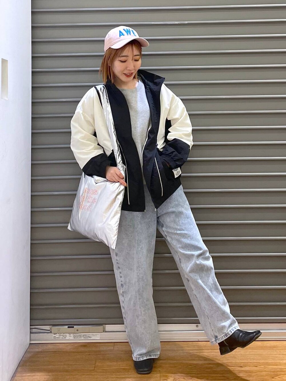 グレー系のTシャツ/カットソー、ブルー系のデニムパンツ、シルバー系のトートバッグを着用したレディースの冬コーディネートの2枚目の写真