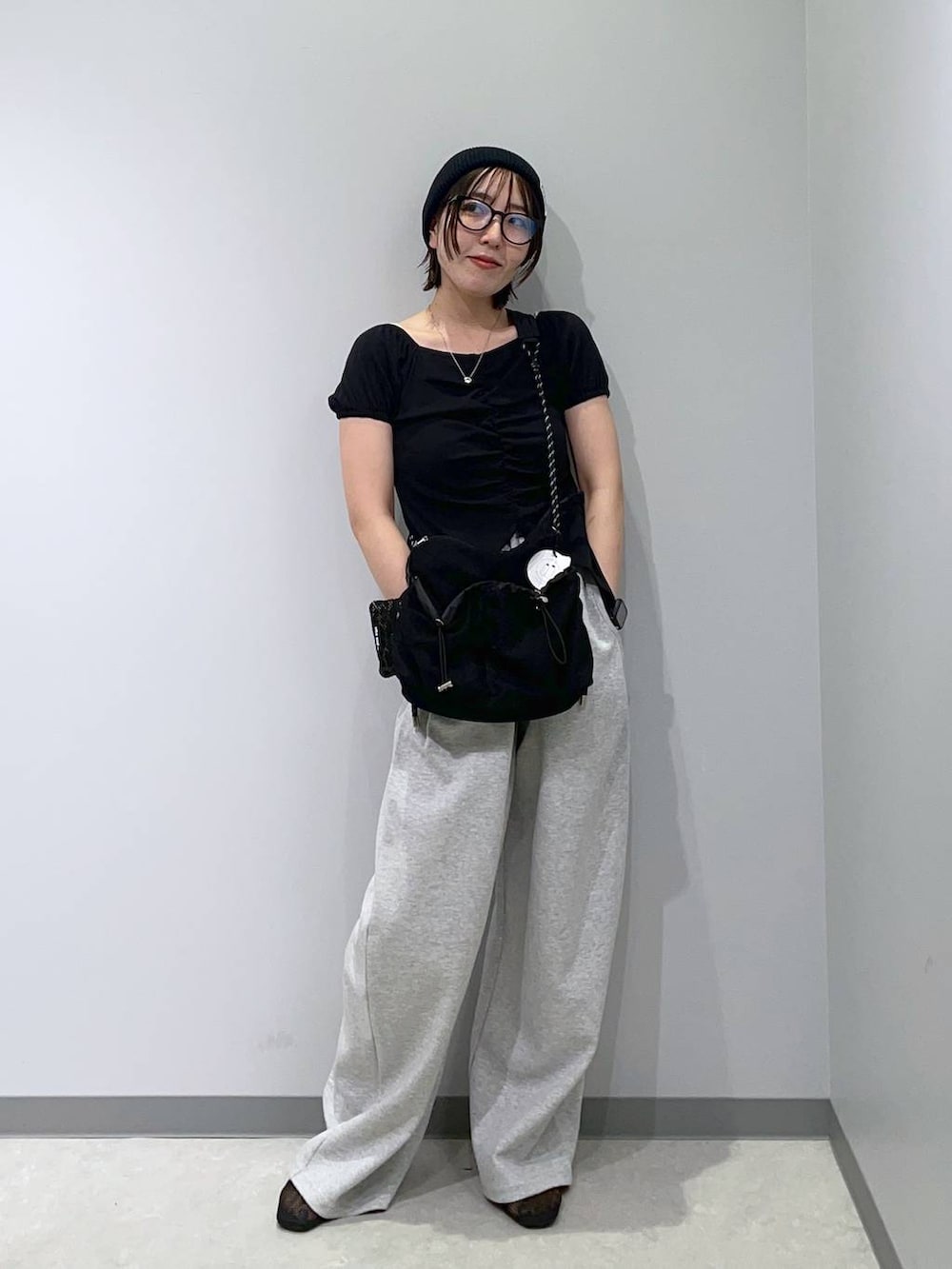 ブラック系のショルダーバッグ、グレー系のスウェットパンツ、ブラック系のTシャツ/カットソーを着用したレディースの夏コーディネートの2枚目の写真