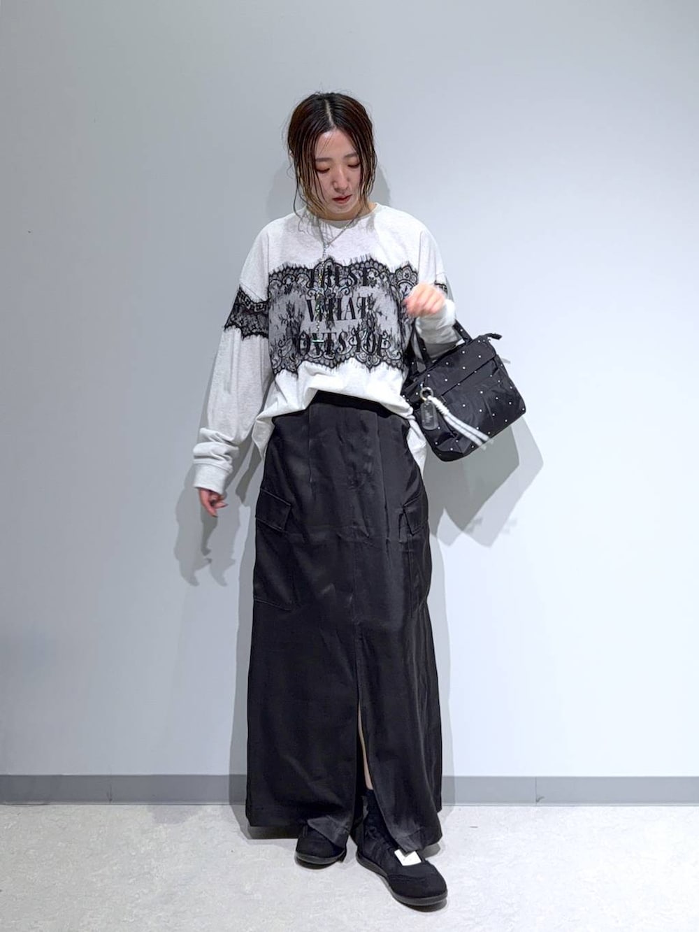 ブラック系のパンプス、ブラック系のスカート、グレー系のTシャツ/カットソーを着用したレディースの夏コーディネートの3枚目の写真
