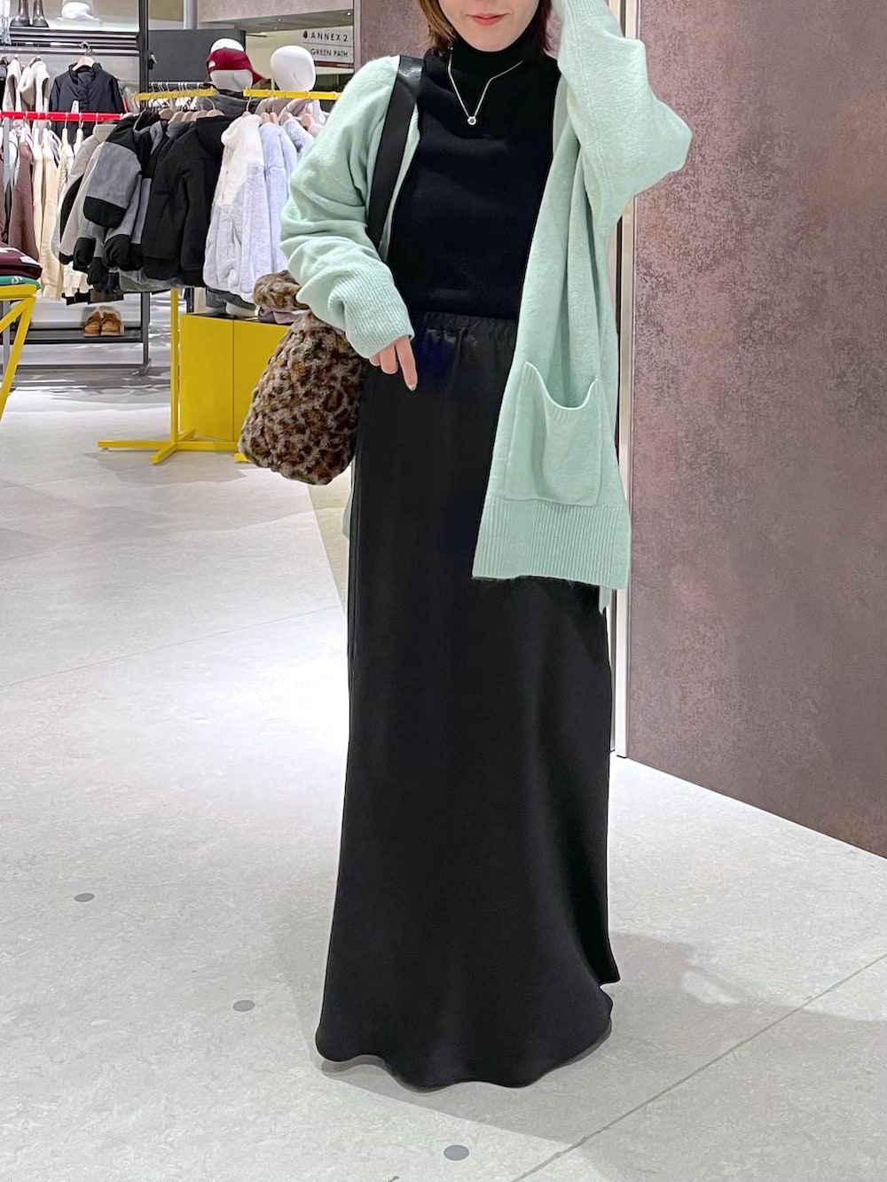 ブラック系のスカート、ブラック系のニット/セーター、その他のトートバッグを着用したレディースの冬コーディネートの2枚目の写真