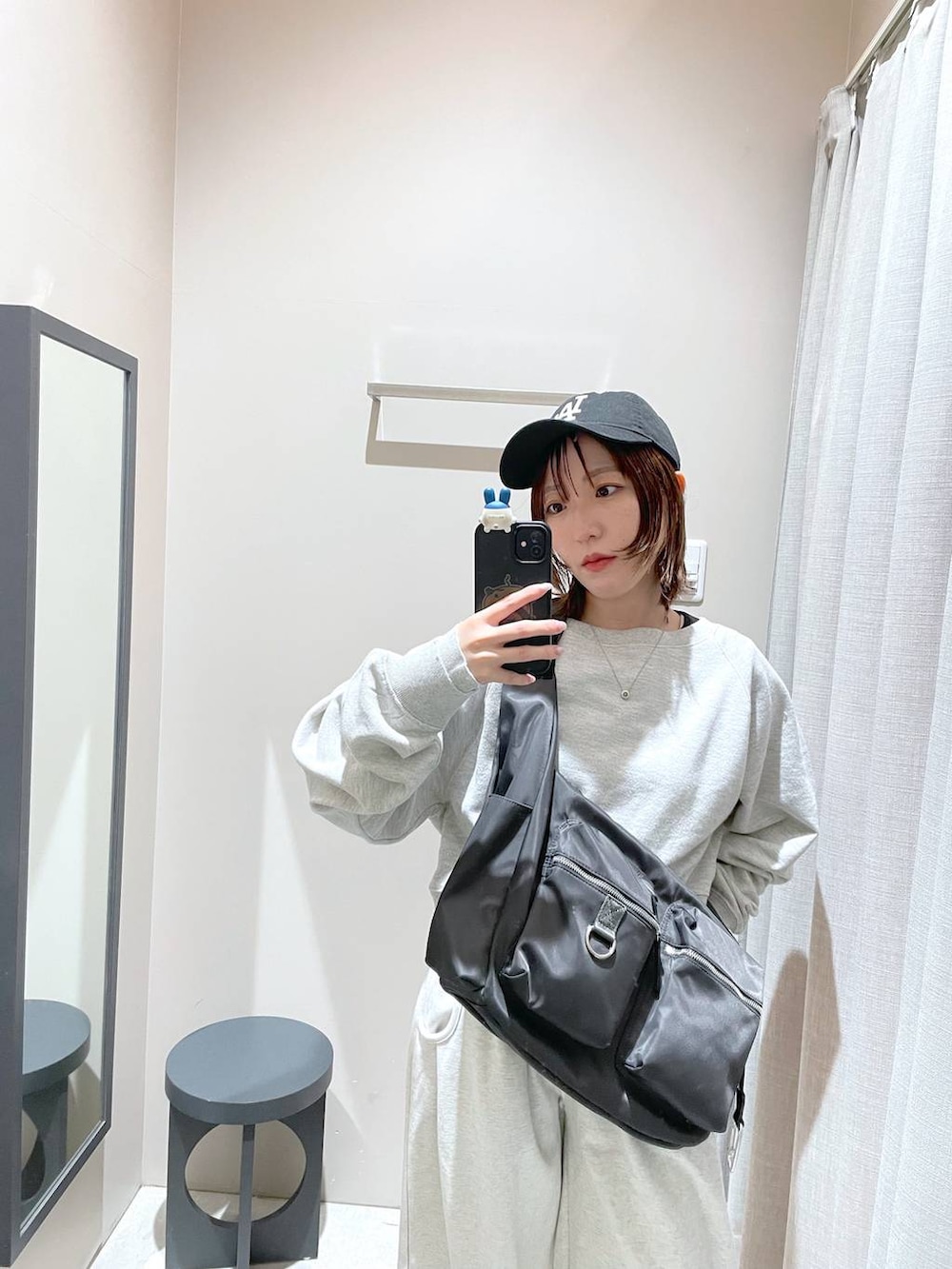 グレー系のショルダーバッグ、グレー系のスウェット、ベージュ系のスウェットパンツを着用したレディースの冬コーディネートの5枚目の写真