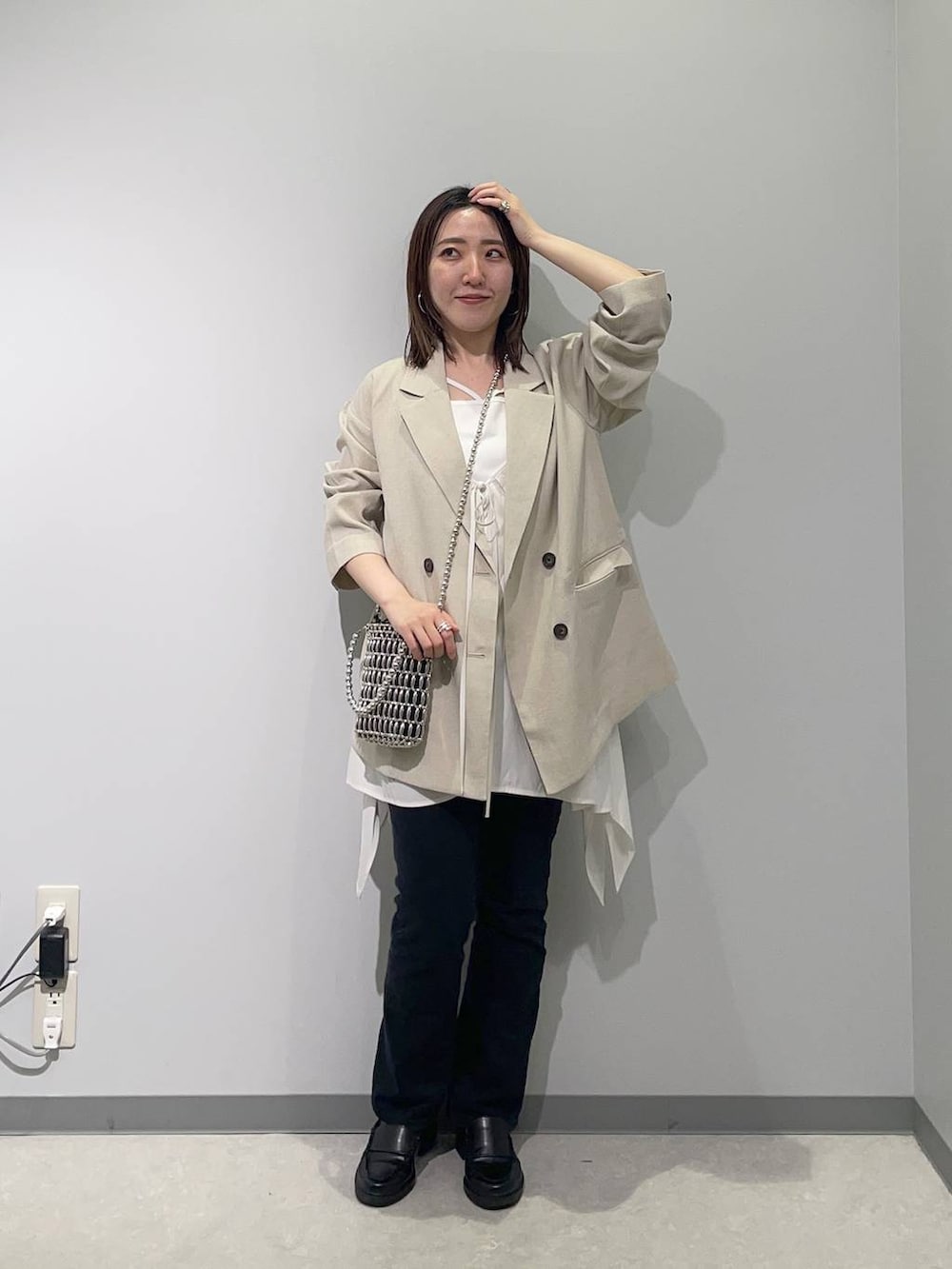 グレー系のその他アウター、シルバー系のショルダーバッグ、ホワイト系のタンクトップを着用したレディースの春コーディネートの2枚目の写真