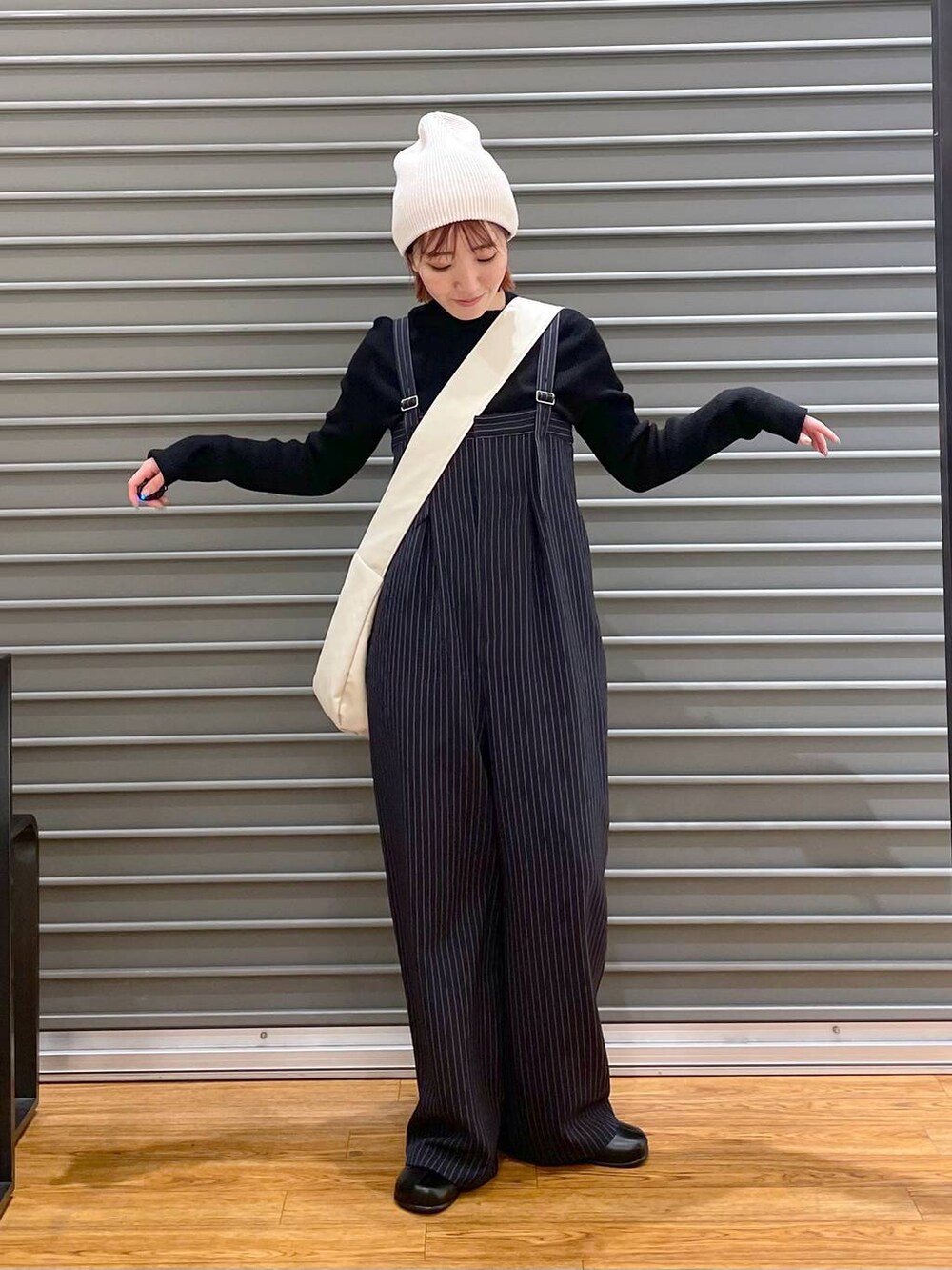 ブラック系のニット/セーター、ホワイト系のショルダーバッグ、ブルー系のその他パンツを着用したレディースの冬コーディネートの6枚目の写真