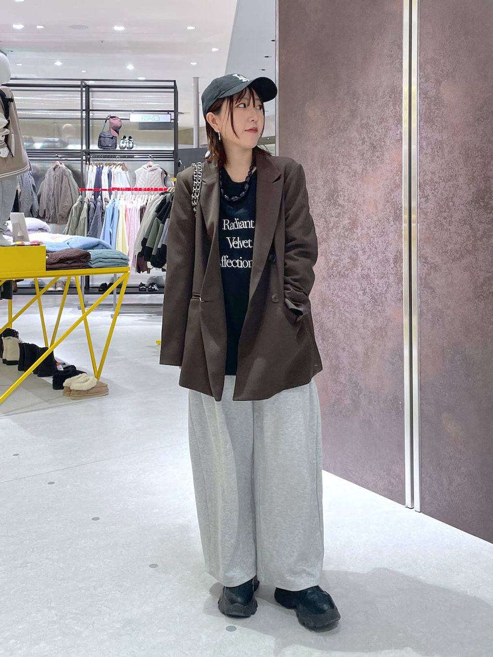 ブラック系のショルダーバッグ、ブラウン系のテーラードジャケット、ブラック系のキャップを着用したレディースの冬コーディネートの3枚目の写真