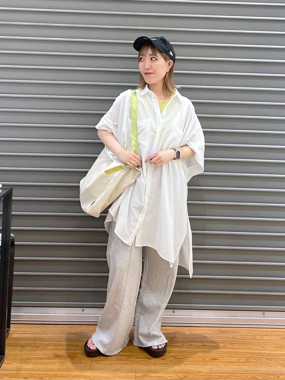 グレー系のスウェットパンツ、ブラック系のサンダル、ホワイト系のチュニックを着用したレディースの春コーディネートの2枚目の写真