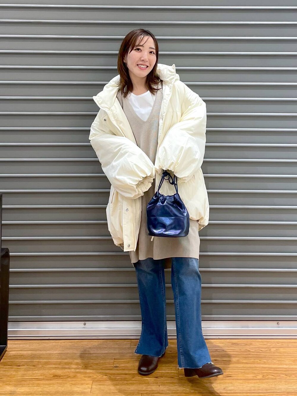 ベージュ系のチュニック、ホワイト系のTシャツ/カットソー、ホワイト系のその他アウターを着用したレディースの冬コーディネートの2枚目の写真