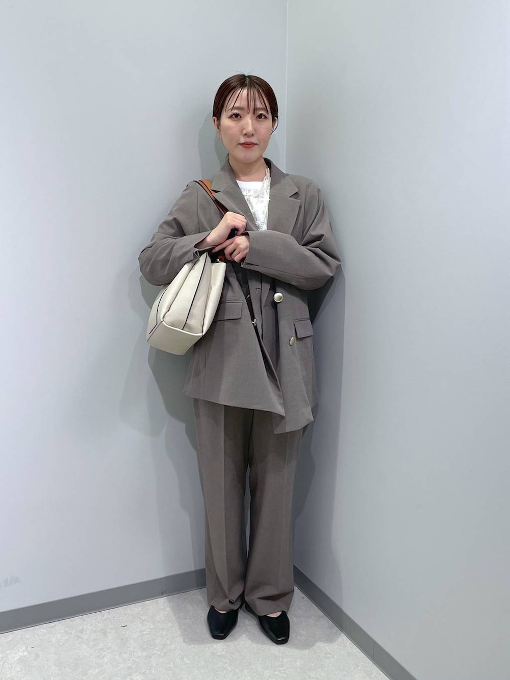 ブラック系のパンプス、ブラウン系のスラックス、ホワイト系のシャツ/ブラウスを着用したレディースの冬コーディネートの4枚目の写真