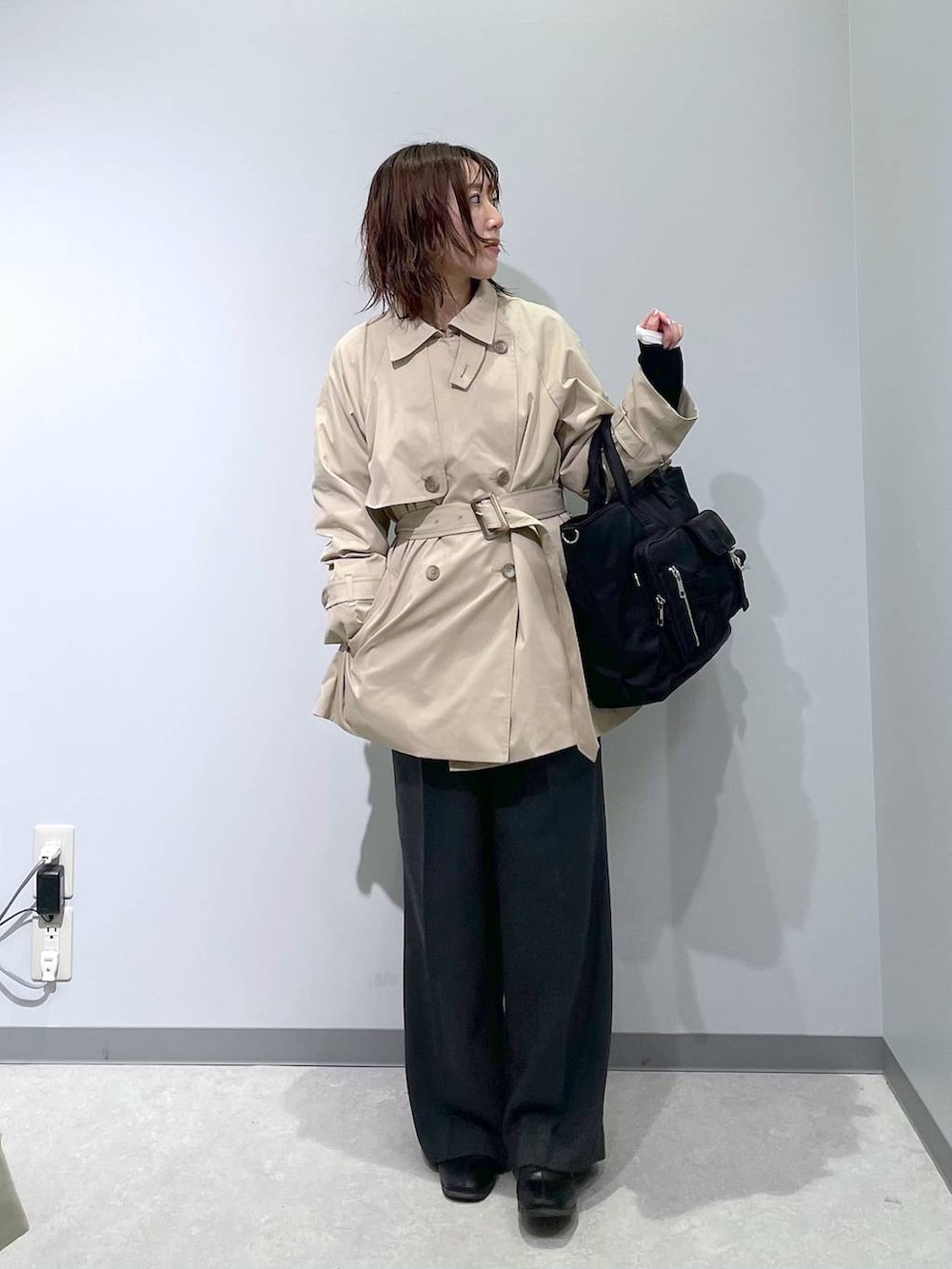 ベージュ系のトレンチコート、ブラック系のトートバッグを着用したレディースの冬コーディネートの5枚目の写真