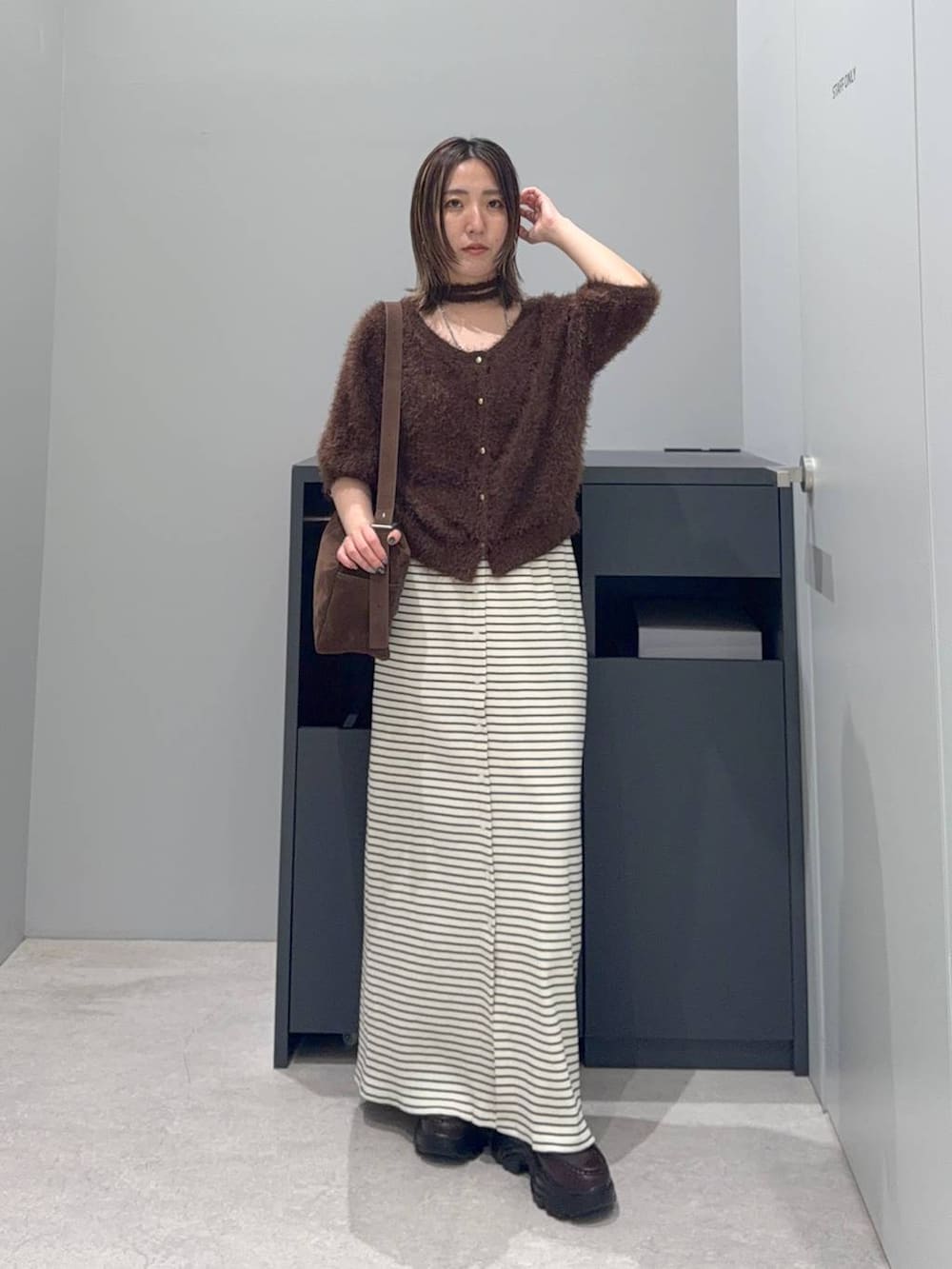 ブラウン系のカーディガン/ボレロ、ホワイト系のスカート、ブラウン系のローファーを着用したレディースの夏コーディネートの4枚目の写真