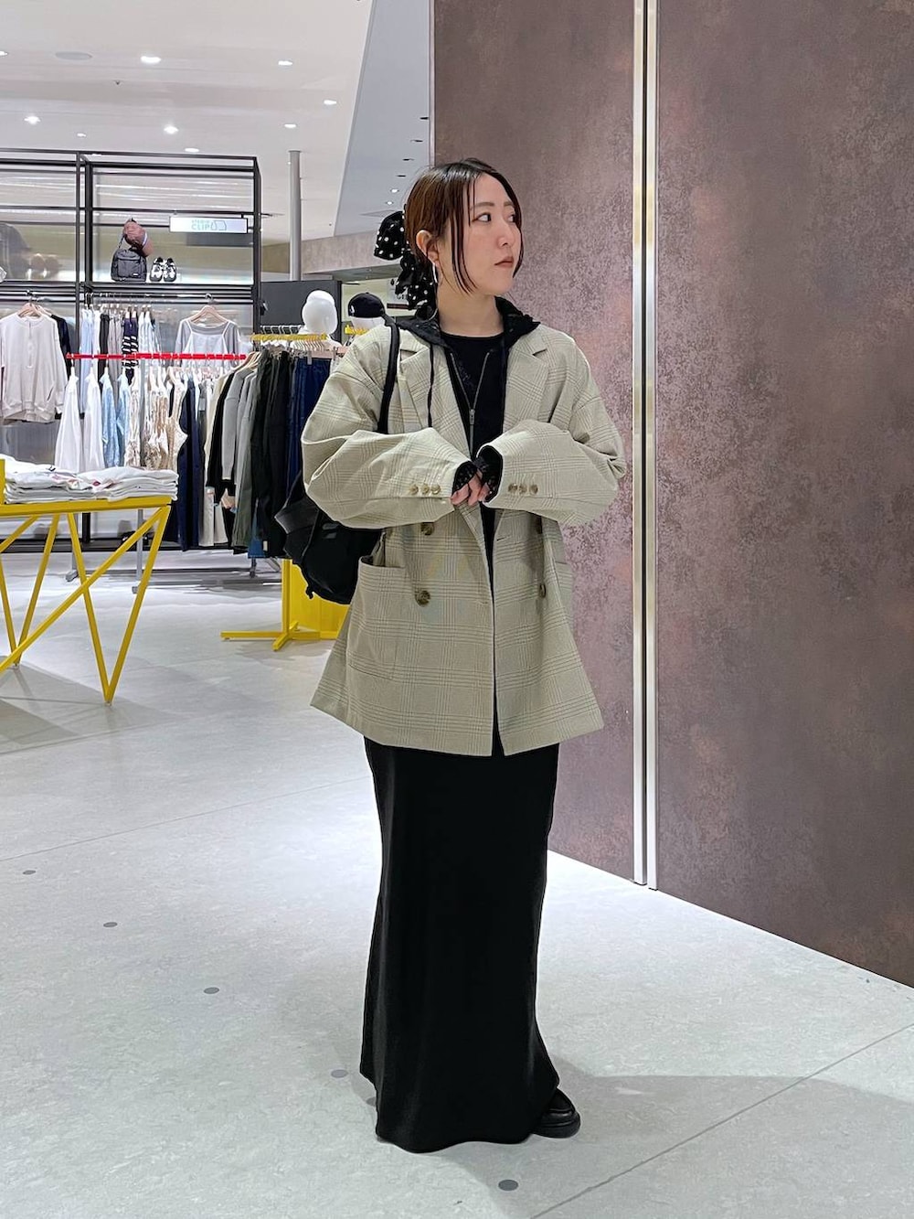 ブラック系のショルダーバッグ、ベージュ系のテーラードジャケット、ブラック系のパーカーを着用したレディースの春コーディネートの4枚目の写真