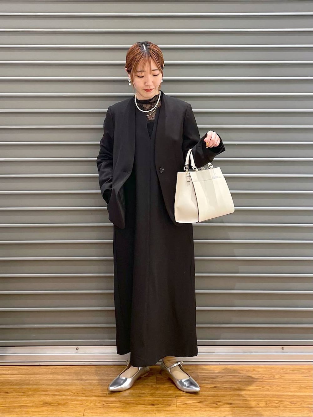 ブラック系のノーカラージャケット、ホワイト系のショルダーバッグ、グレー系のパンプスを着用したレディースの冬コーディネートの4枚目の写真