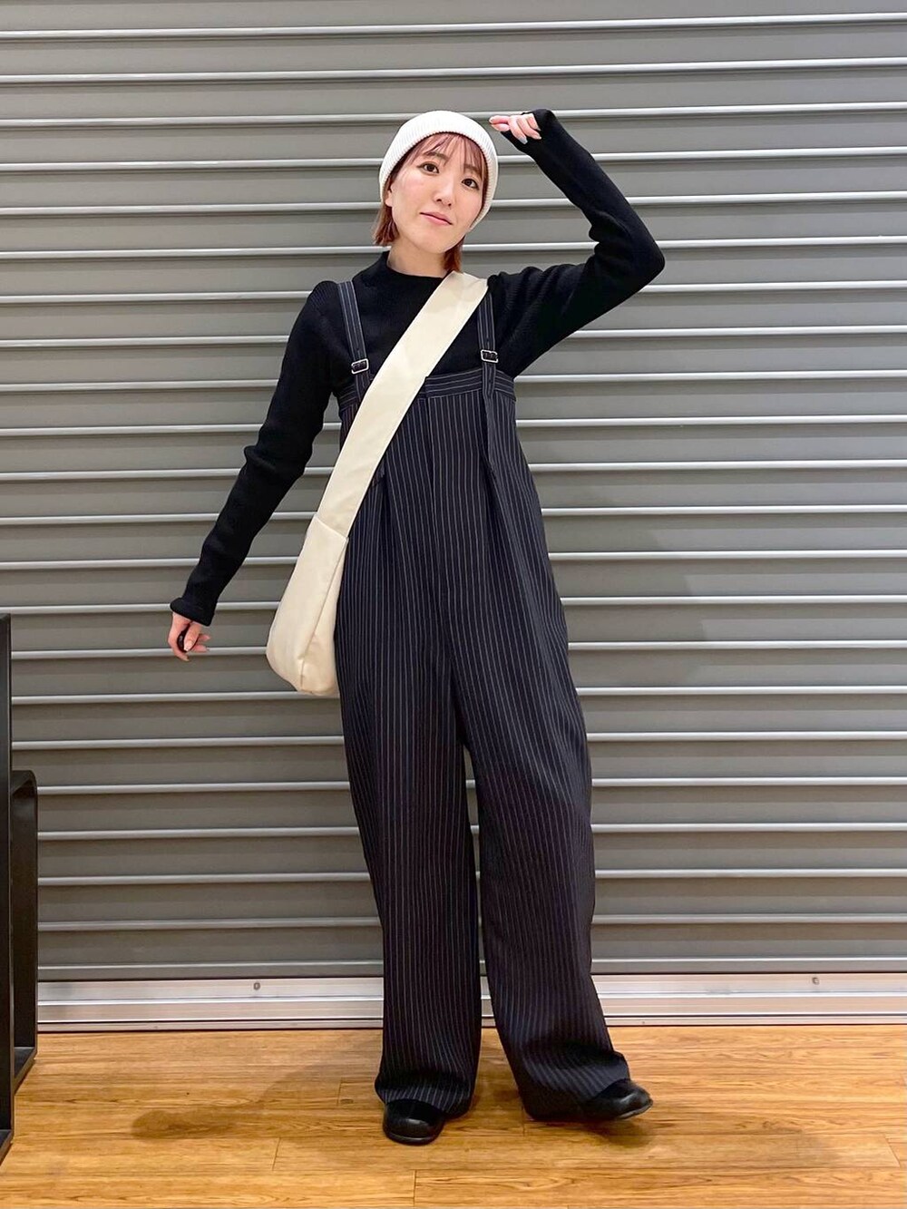 ブラック系のニット/セーター、ホワイト系のショルダーバッグ、ブルー系のその他パンツを着用したレディースの冬コーディネートの2枚目の写真