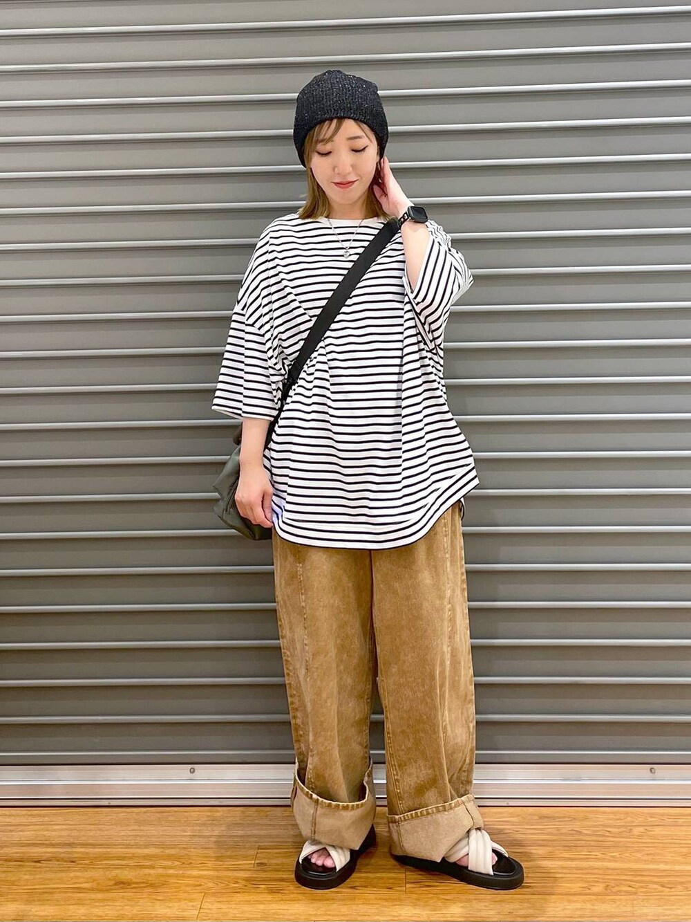 ブラック系のショルダーバッグ、ホワイト系のサンダル、ホワイト系のTシャツ/カットソーを着用したレディースの夏コーディネートの3枚目の写真