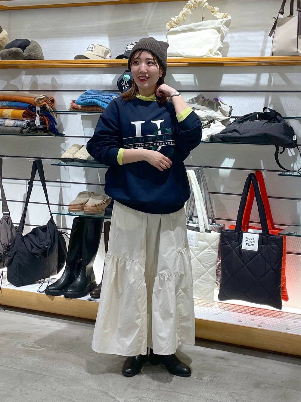 ホワイト系のスカート、ブラック系のブーツ、イエロー系のTシャツ/カットソーを着用したレディースの冬コーディネートの4枚目の写真