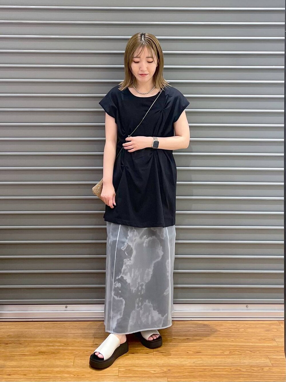 その他のショルダーバッグ、ブラック系のスカート、ホワイト系のサンダルを着用したレディースの夏コーディネートの2枚目の写真