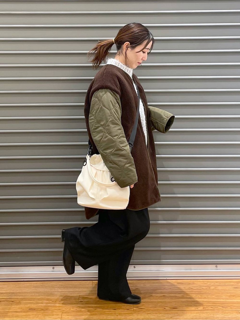 ブラック系のその他パンツ、ホワイト系のショルダーバッグ、グリーン系のマタニティウェア/グッズを着用したレディースの冬コーディネートの3枚目の写真