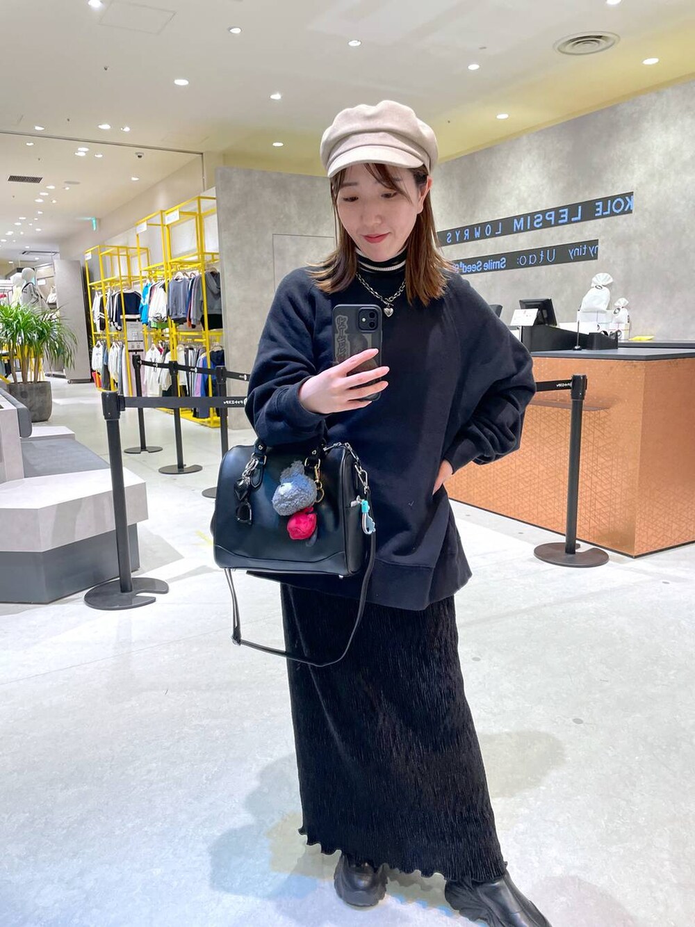 ブラック系のスウェット、ブラック系のスカートを着用したレディースの春コーディネートの2枚目の写真