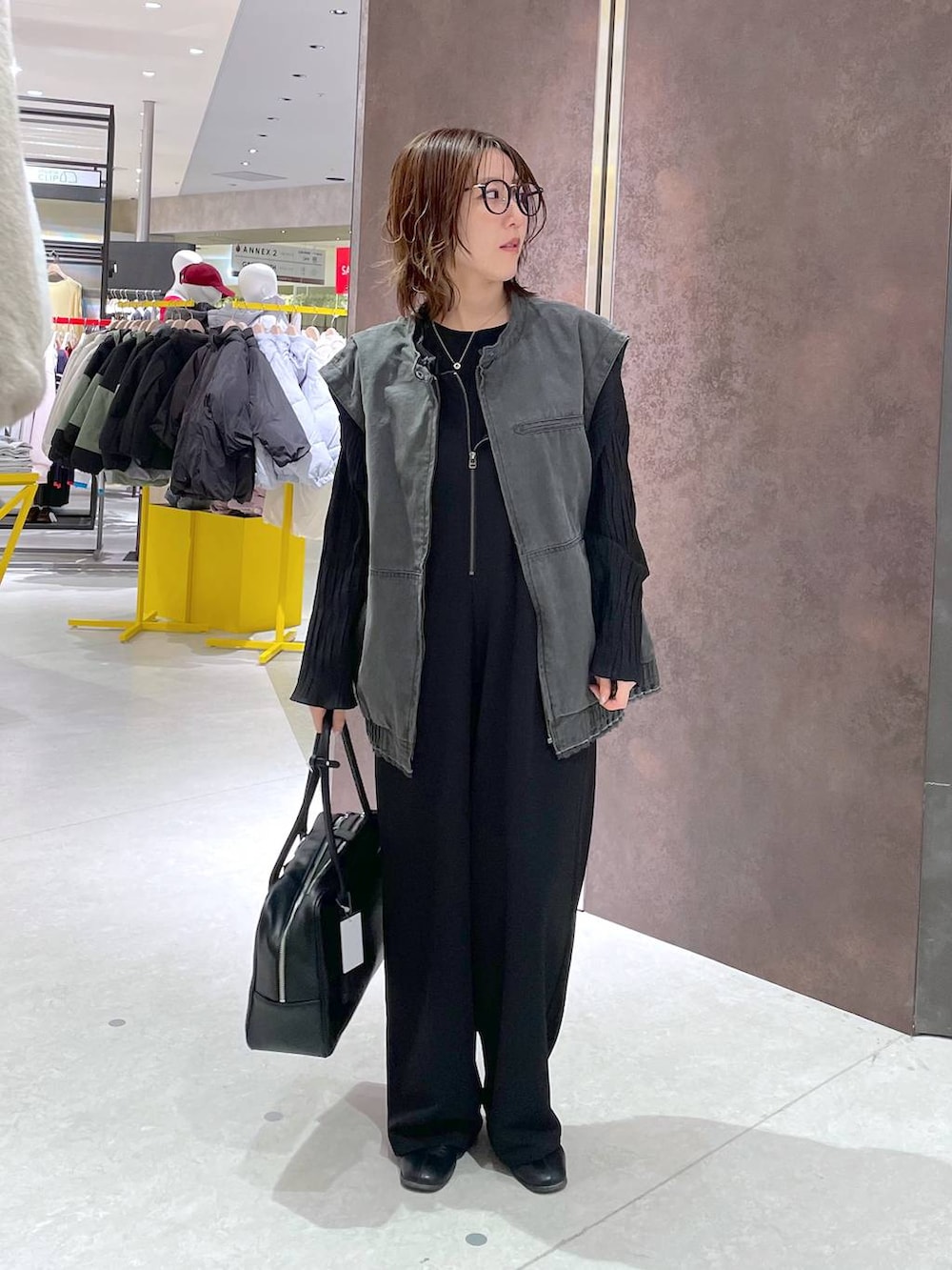 ブラック系のブルゾン、ブラック系のサロペット/オーバーオール、ブラック系のボストンバッグを着用したレディースの冬コーディネートの4枚目の写真