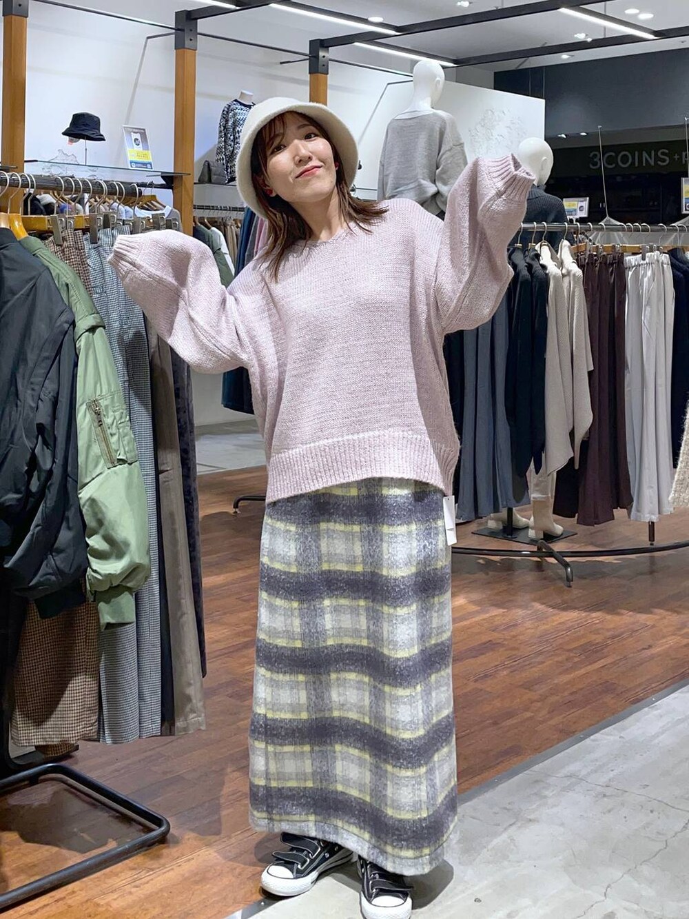 グレー系のスカート、ピンク系のニット/セーター、ホワイト系のハットを着用したレディースの冬コーディネートの2枚目の写真