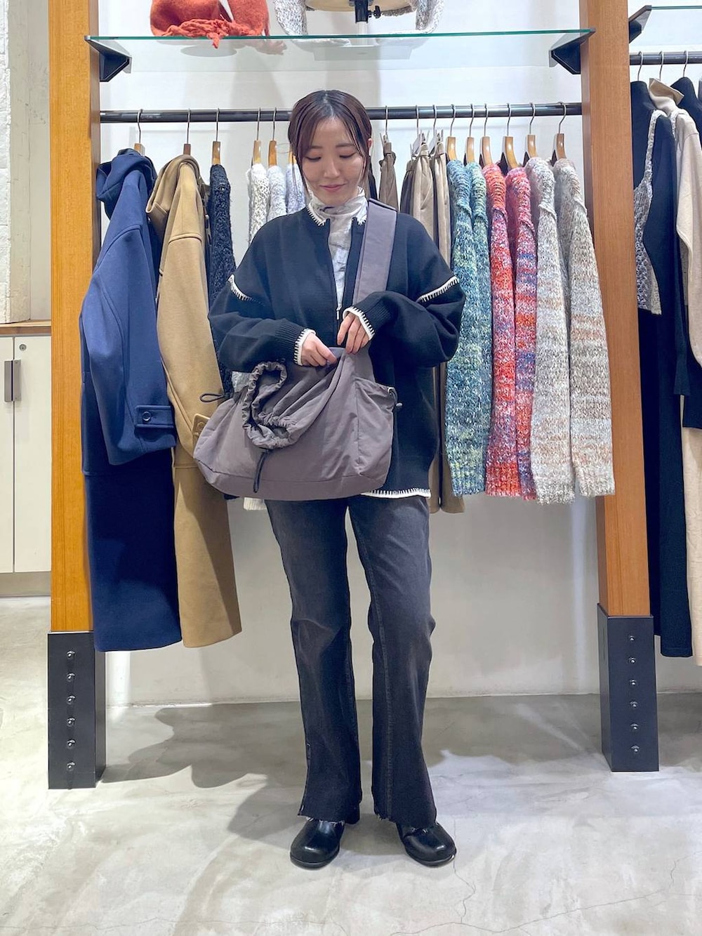 ブラック系のデニムパンツ、ブラック系のブーツ、グレー系のTシャツ/カットソーを着用したレディースの冬コーディネートの2枚目の写真