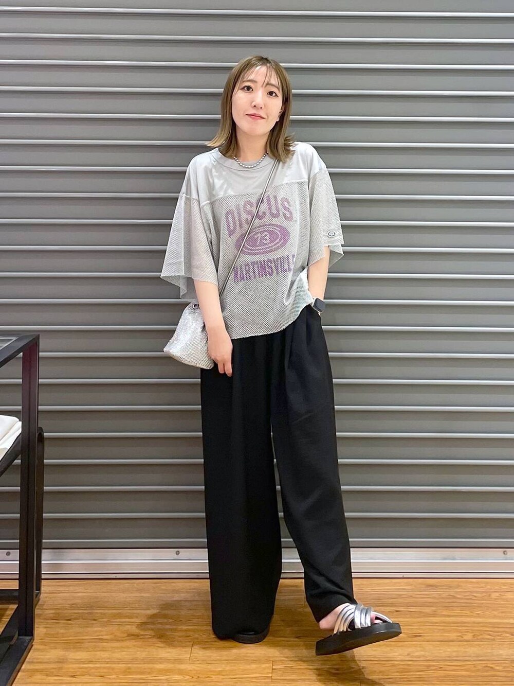 シルバー系のショルダーバッグ、ブラック系のその他パンツ、シルバー系のサンダルを着用したレディースの夏コーディネートの2枚目の写真