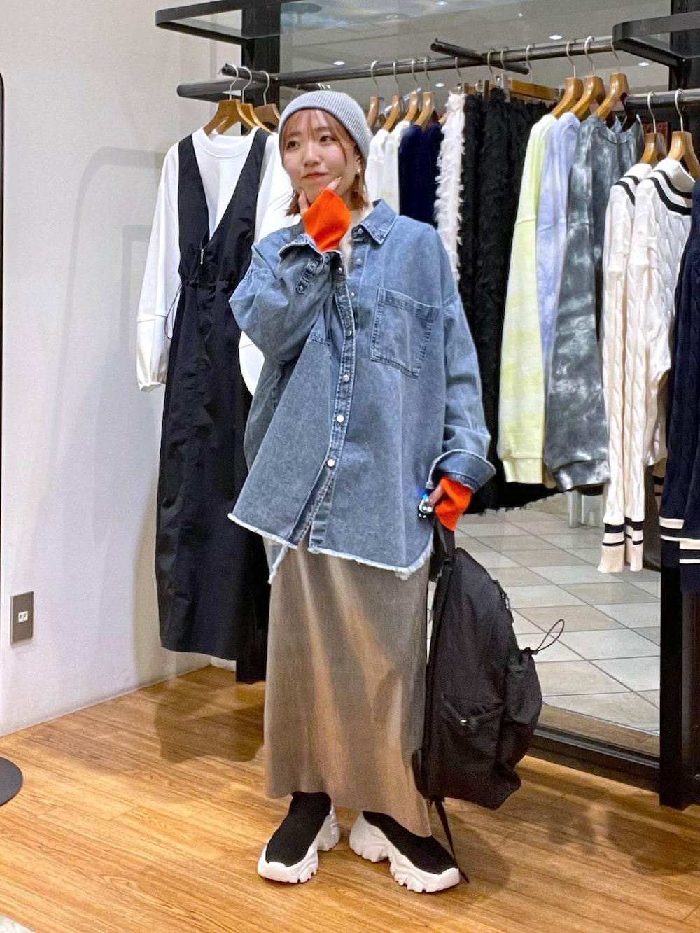 グレー系のスカート、ブラック系のバックパック/リュック、ブルー系のシャツ/ブラウスを着用したレディースの冬コーディネートの4枚目の写真