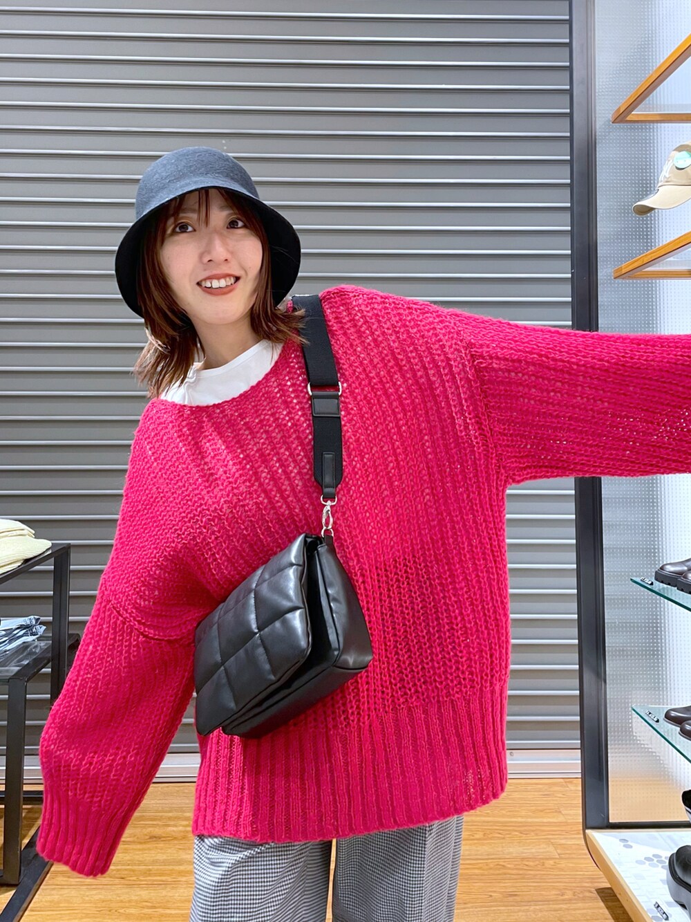 ピンク系のニット/セーター、ブラック系のショルダーバッグ、ホワイト系のTシャツ/カットソーを着用したレディースの秋コーディネートの4枚目の写真