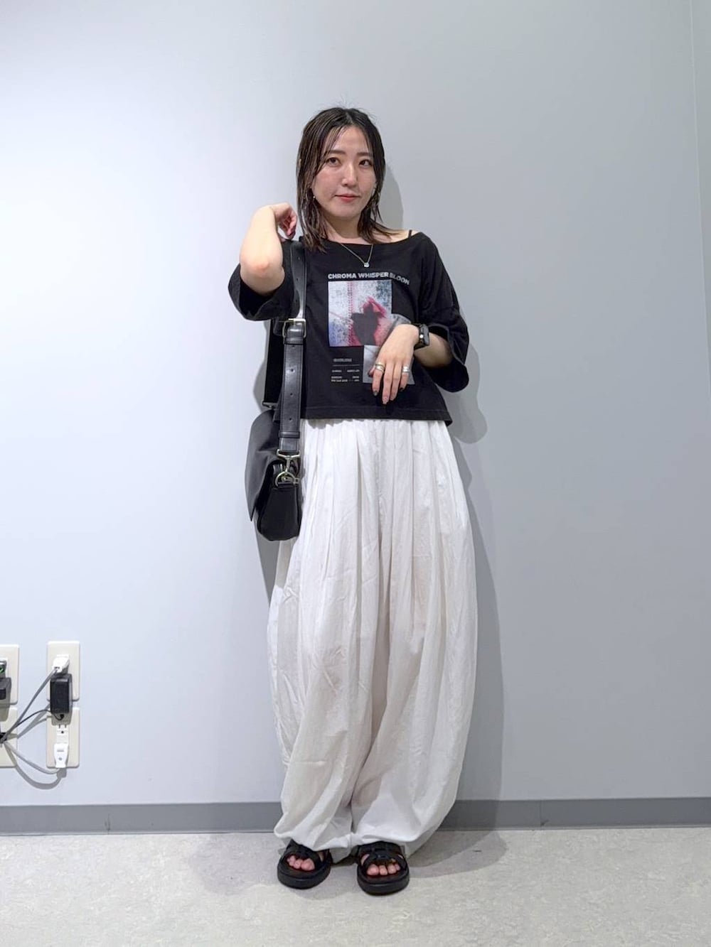 ブラック系のショルダーバッグ、ブラック系のサンダル、ホワイト系のカーゴパンツを着用したレディースの夏コーディネートの2枚目の写真