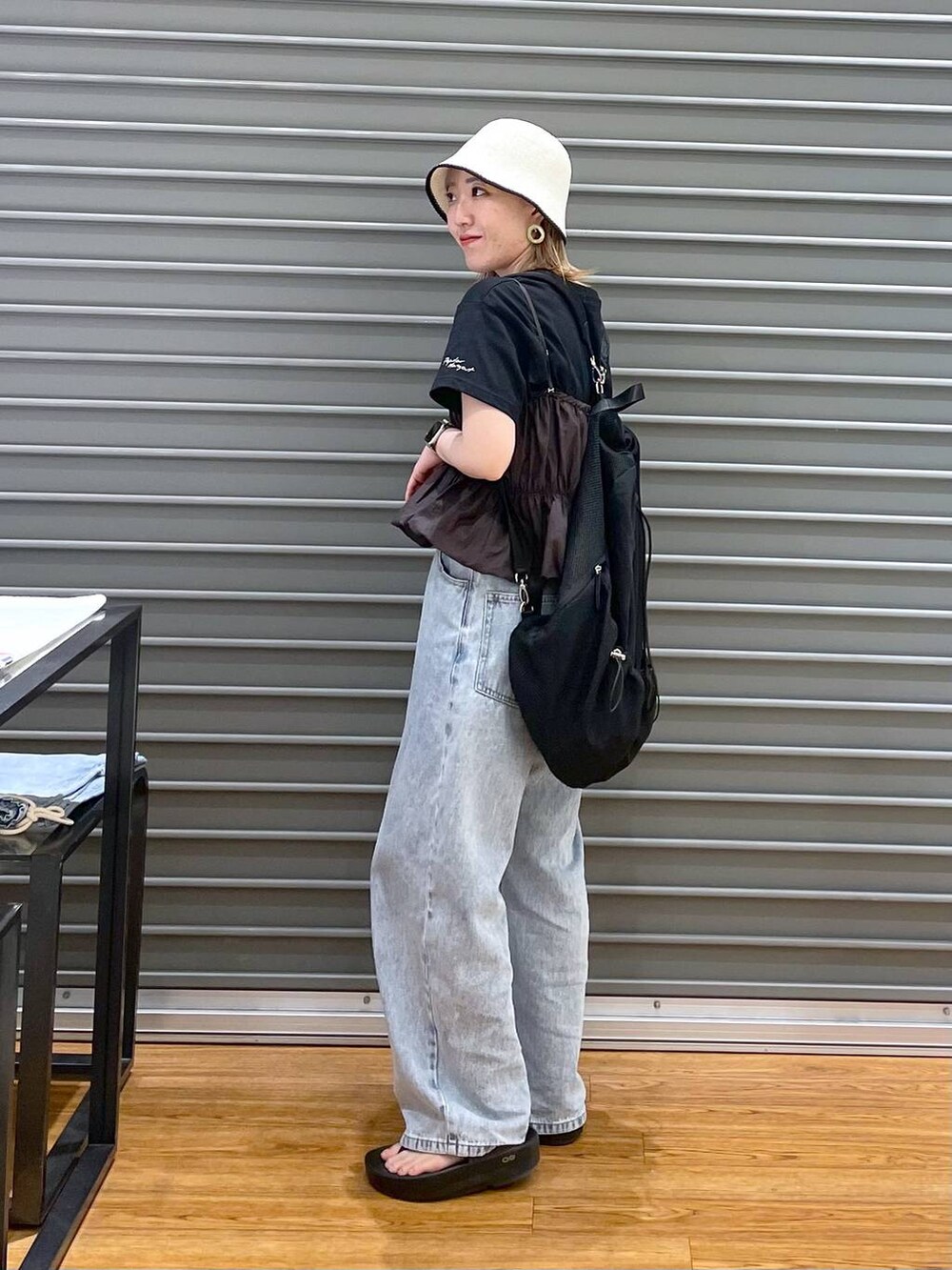 ブラウン系のシャツ/ブラウス、ブラック系のTシャツ/カットソー、ブルー系のデニムパンツを着用したレディースの春コーディネートの2枚目の写真