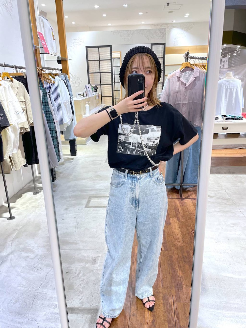 ブラック系のTシャツ/カットソー、ブルー系のデニムパンツ、シルバー系のスマホグッズを着用したレディースの夏コーディネートの3枚目の写真