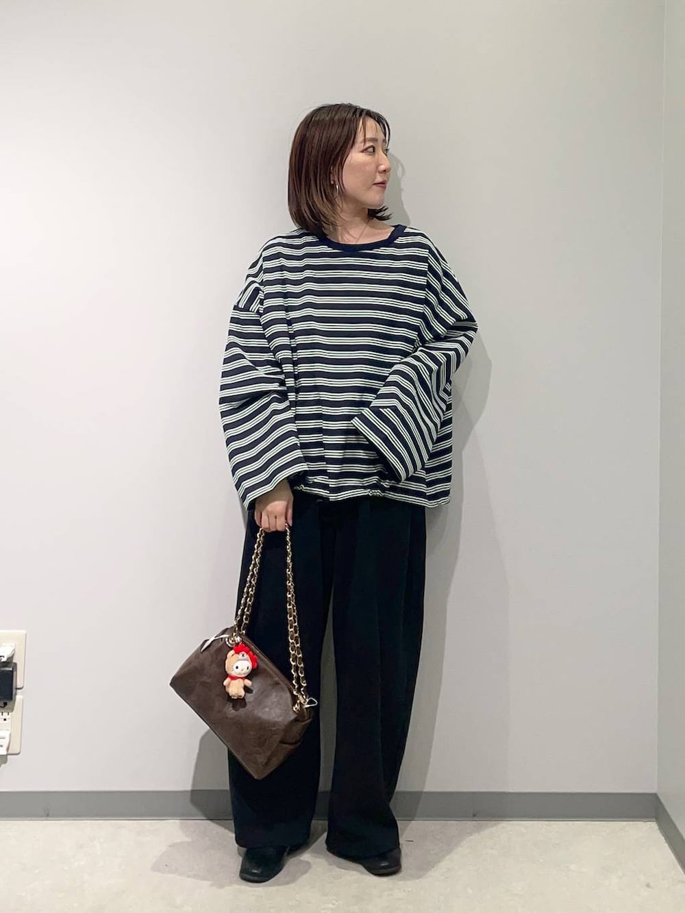 ブラウン系のショルダーバッグ、ブルー系のTシャツ/カットソーを着用したレディースの春コーディネートの2枚目の写真