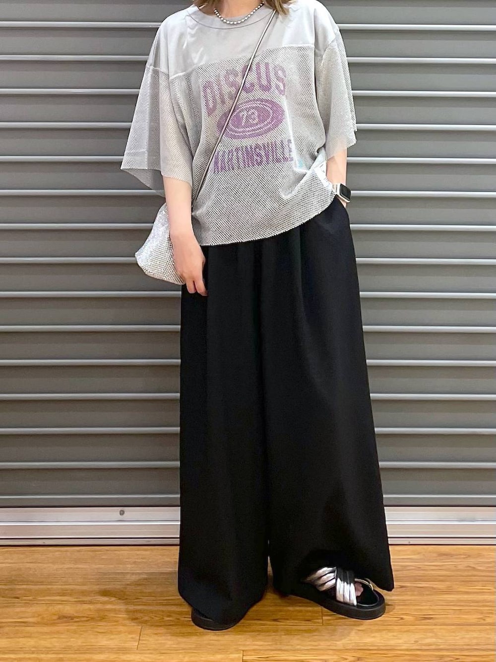 シルバー系のショルダーバッグ、ブラック系のその他パンツ、シルバー系のサンダルを着用したレディースの夏コーディネートの3枚目の写真