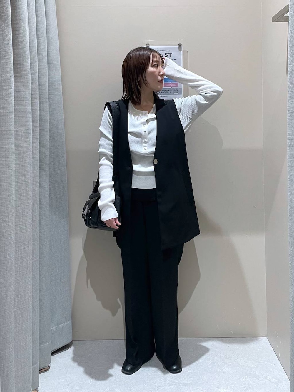 ブラック系のその他アウター、ホワイト系のニット/セーター、ブラック系のショルダーバッグを着用したレディースの冬コーディネートの5枚目の写真