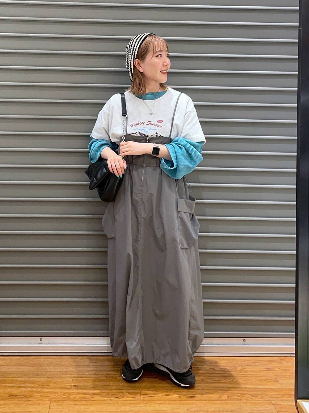 ブラック系のショルダーバッグ、グレー系のTシャツ/カットソー、グレー系のワンピースを着用したレディースの春コーディネートの2枚目の写真