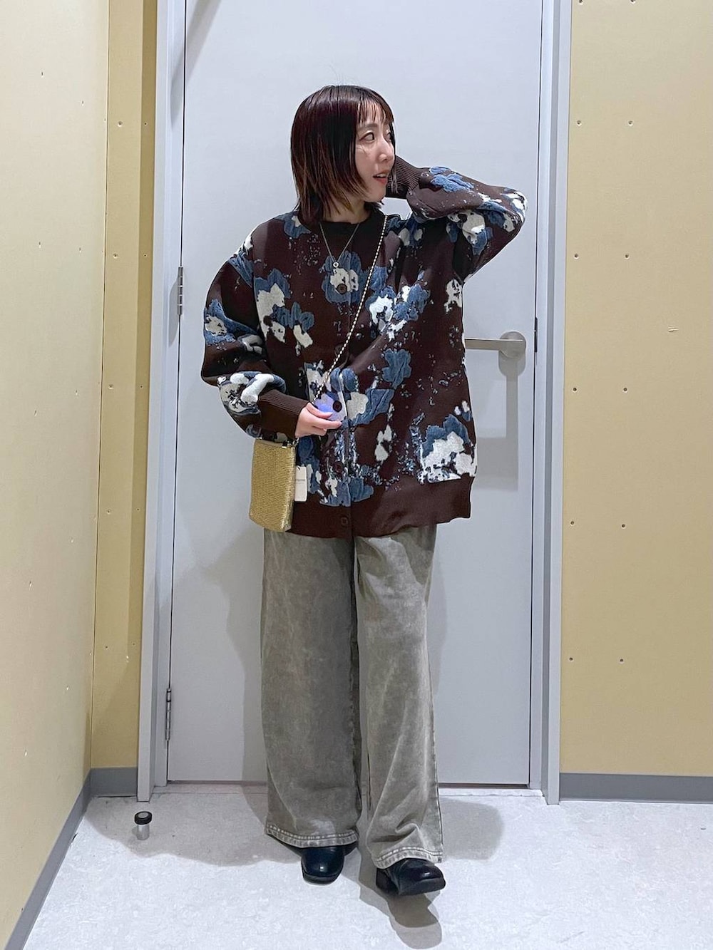 ゴールド系のショルダーバッグ、ブラウン系のカーディガン/ボレロ、グレー系のスウェットパンツを着用したレディースの秋コーディネートの3枚目の写真