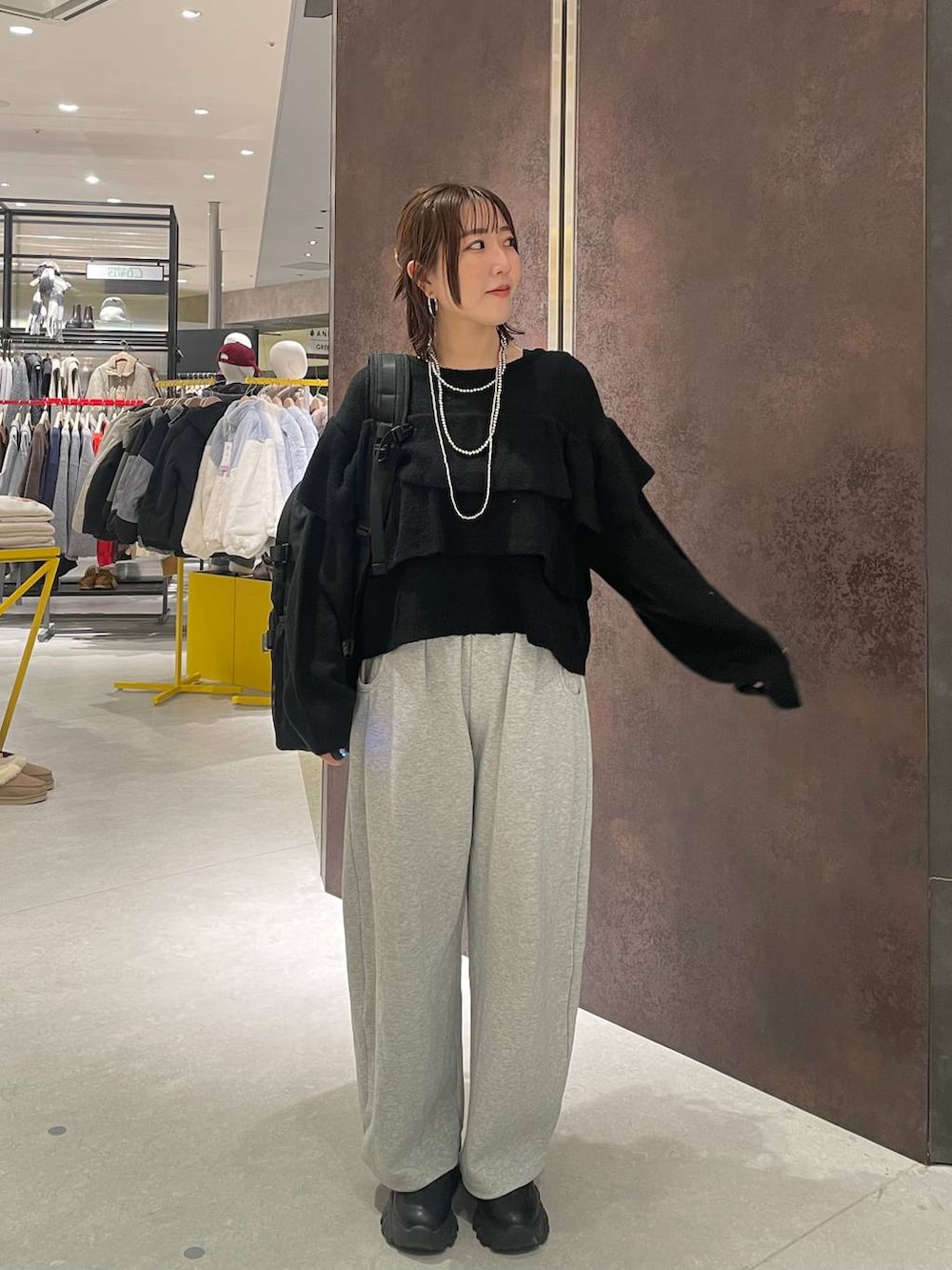 ブラック系のバックパック/リュック、グレー系のスウェットパンツ、ブラック系のニット/セーターを着用したレディースの冬コーディネートの2枚目の写真