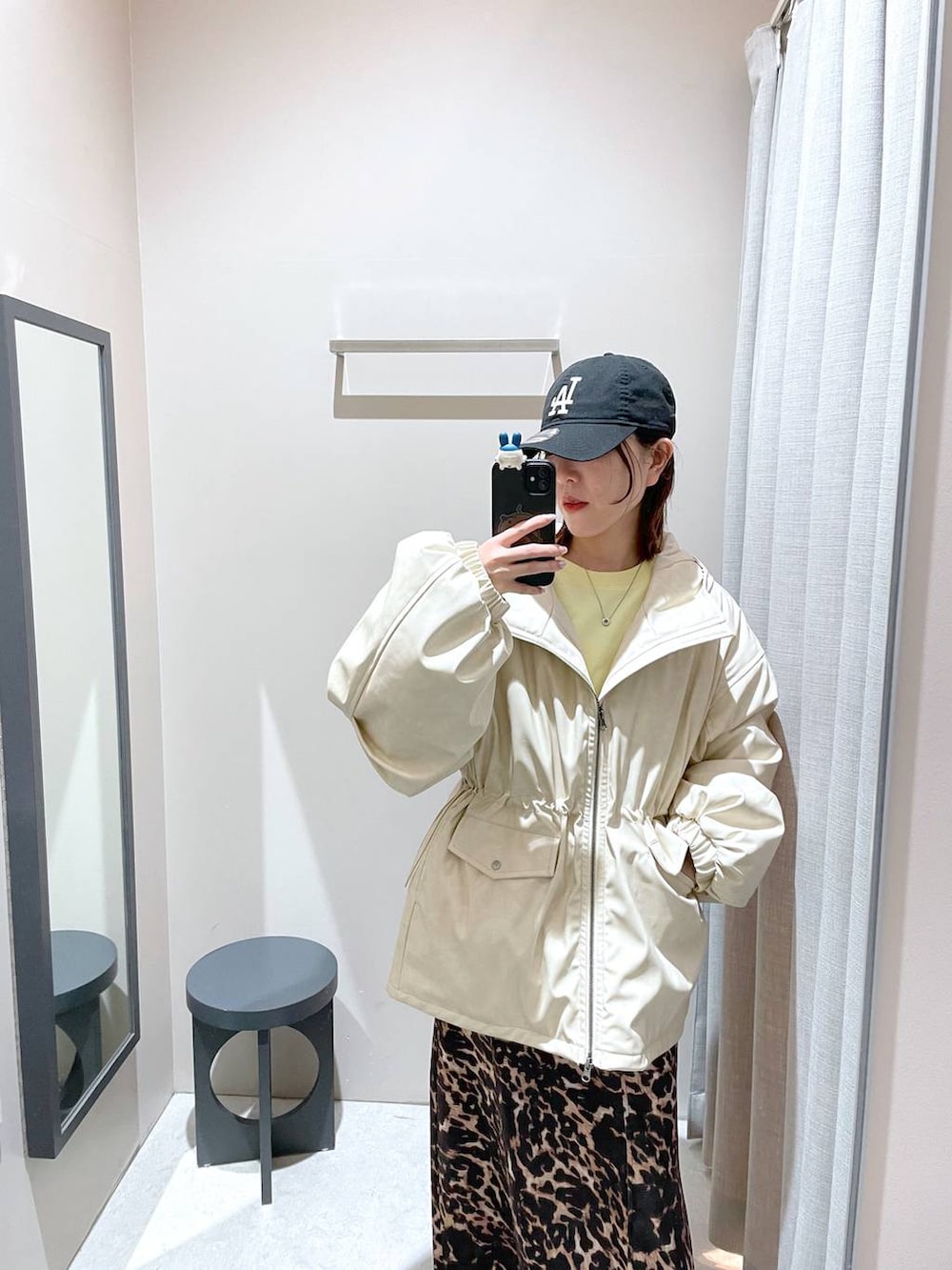 ブラウン系のスカート、ホワイト系のブルゾン、イエロー系のスウェットを着用したレディースの冬コーディネートの7枚目の写真