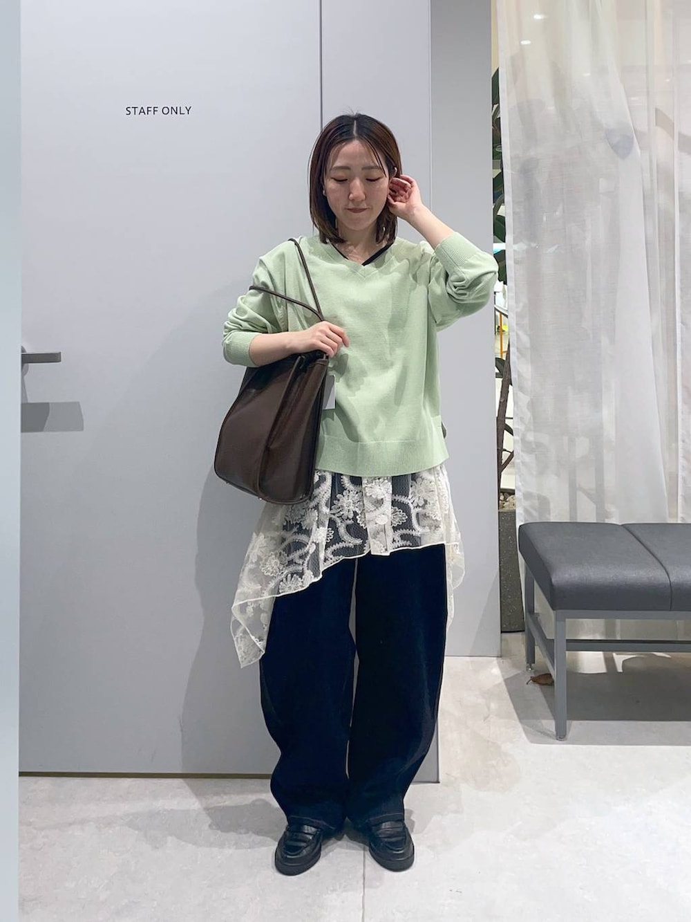 ブルー系のデニムパンツ、ホワイト系のその他トップス、グリーン系のニット/セーターを着用したレディースの春コーディネートの2枚目の写真