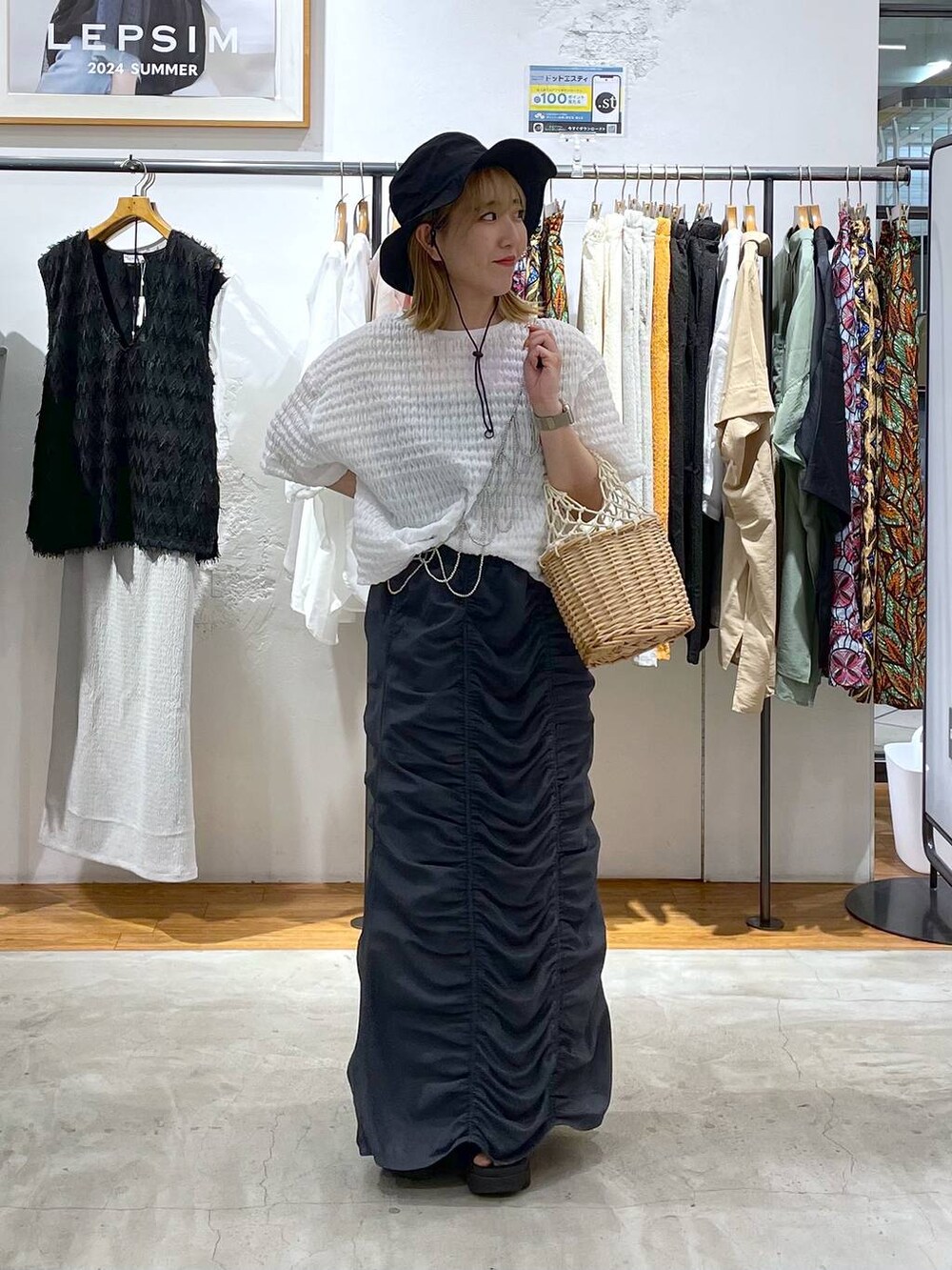 ホワイト系のかごバッグ、グレー系のスカート、ホワイト系のTシャツ/カットソーを着用したレディースの夏コーディネートの2枚目の写真