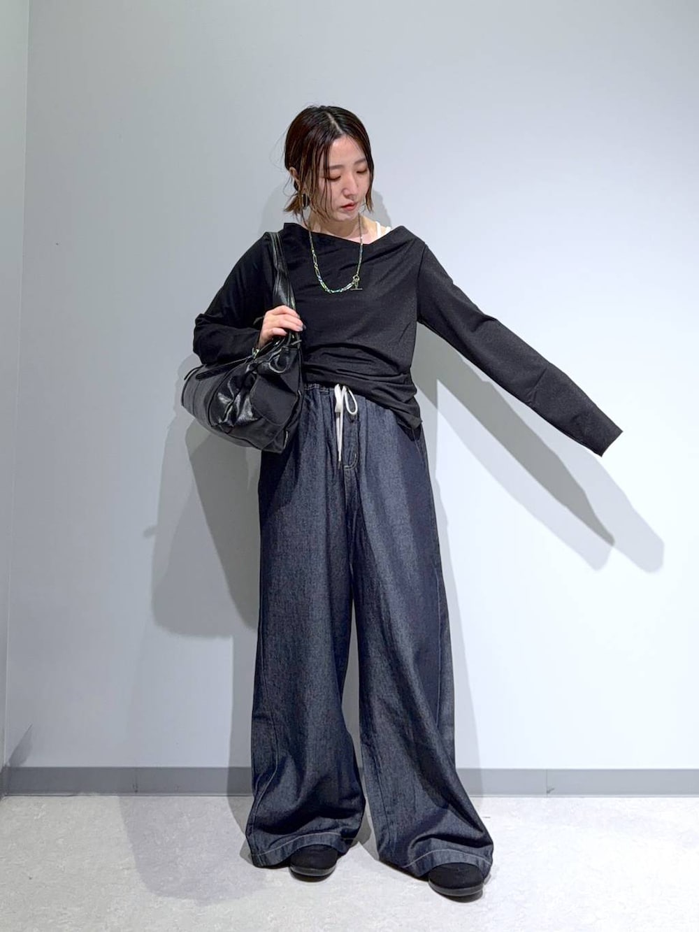 ブラック系のパンプス、ブラック系のTシャツ/カットソー、ブラック系のトートバッグを着用したレディースの秋コーディネートの2枚目の写真